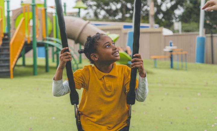 Student with a big smile having fun on the swing