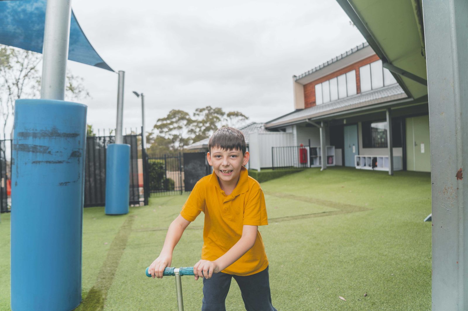 Student smiling while riding a scooter