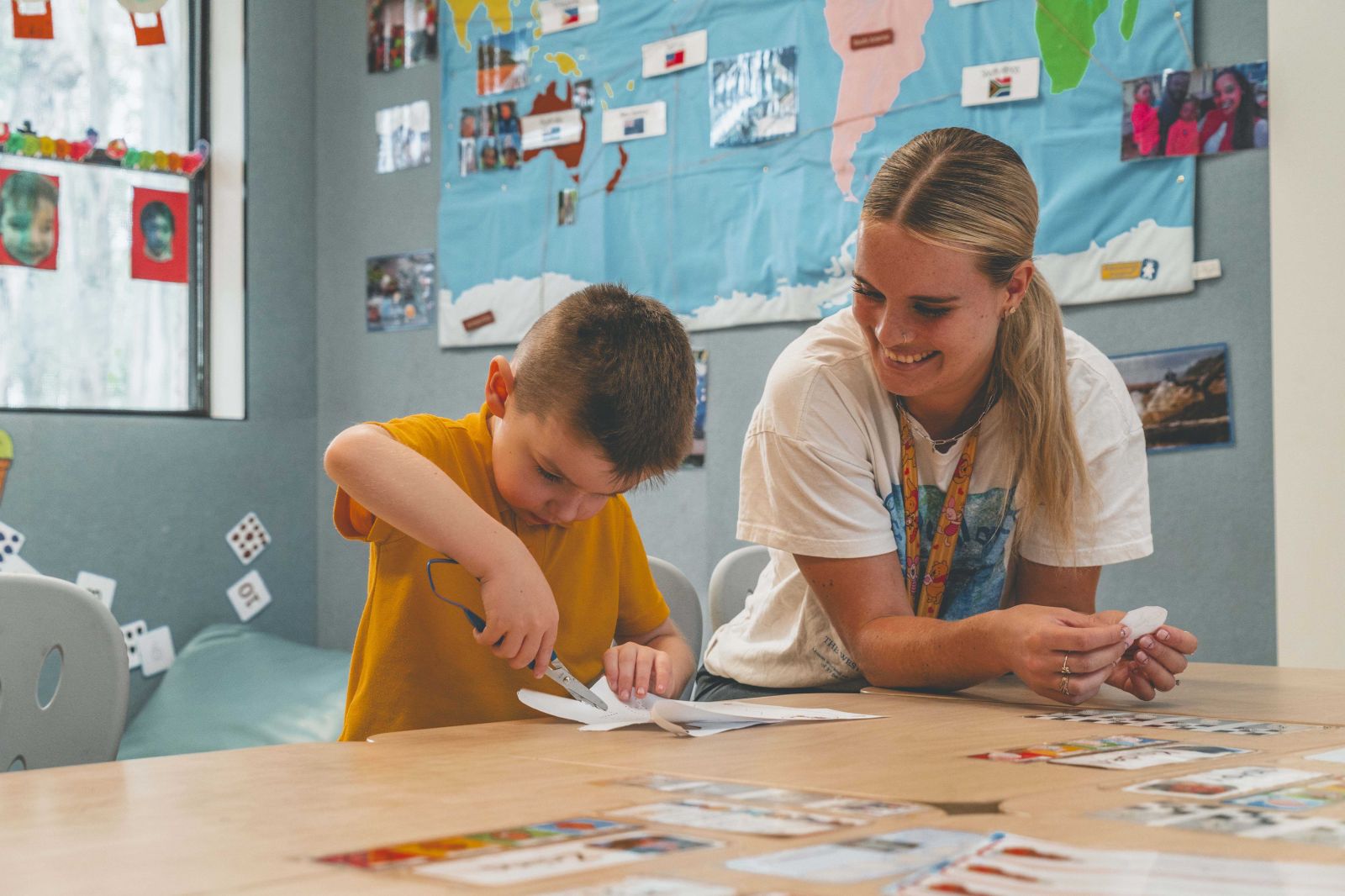 A teacher supporting a student while he works