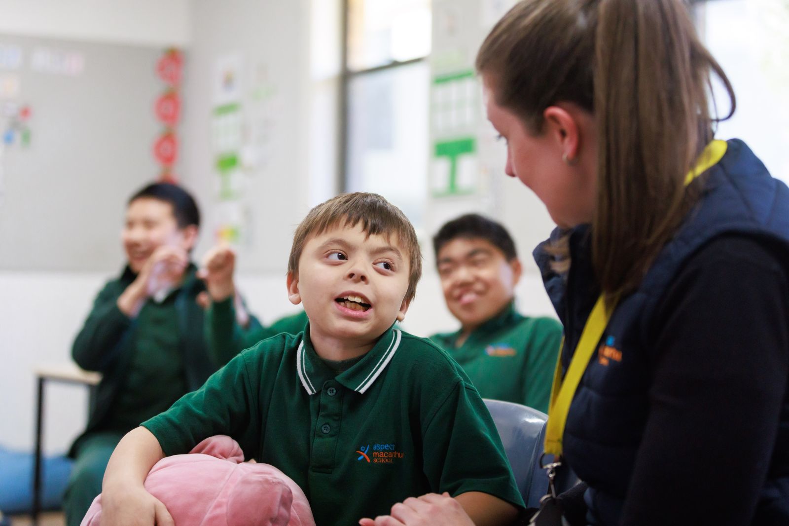 Student smiling with teacher in classroom.