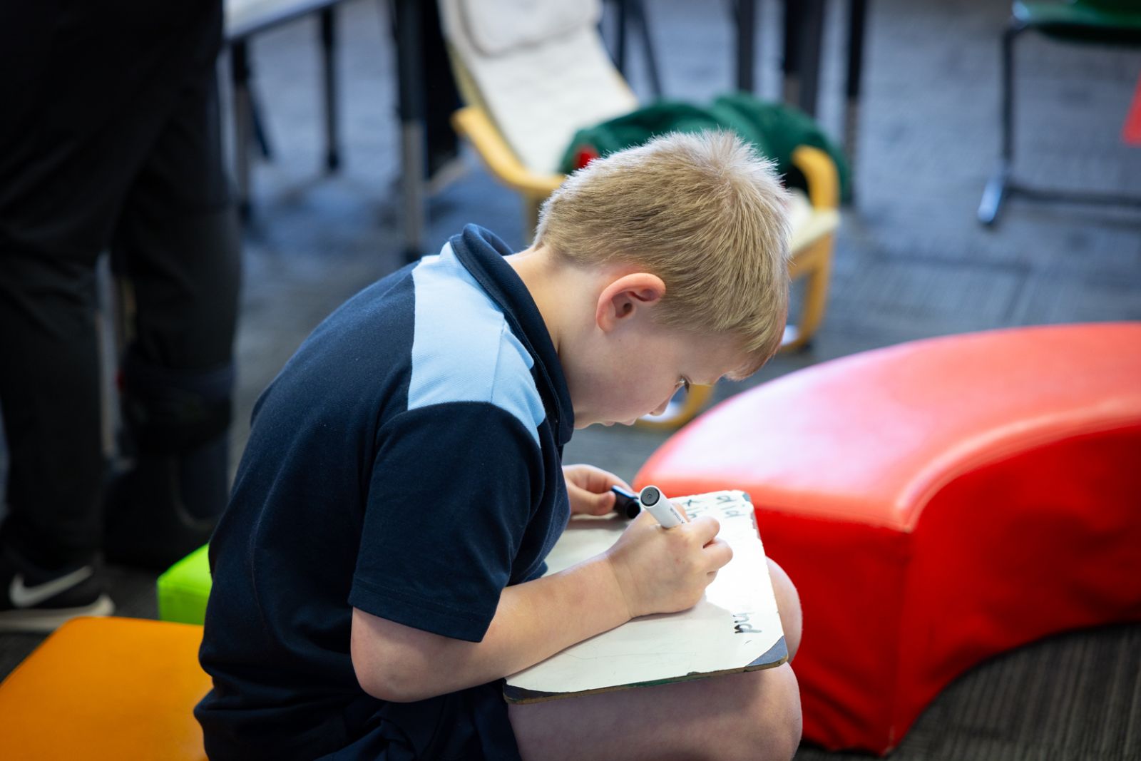 Student writes on a whiteboard in the classroom