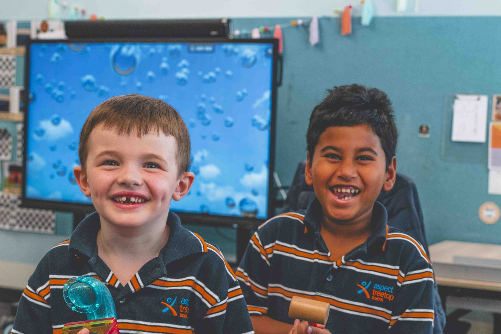 Two students smiling and playing together